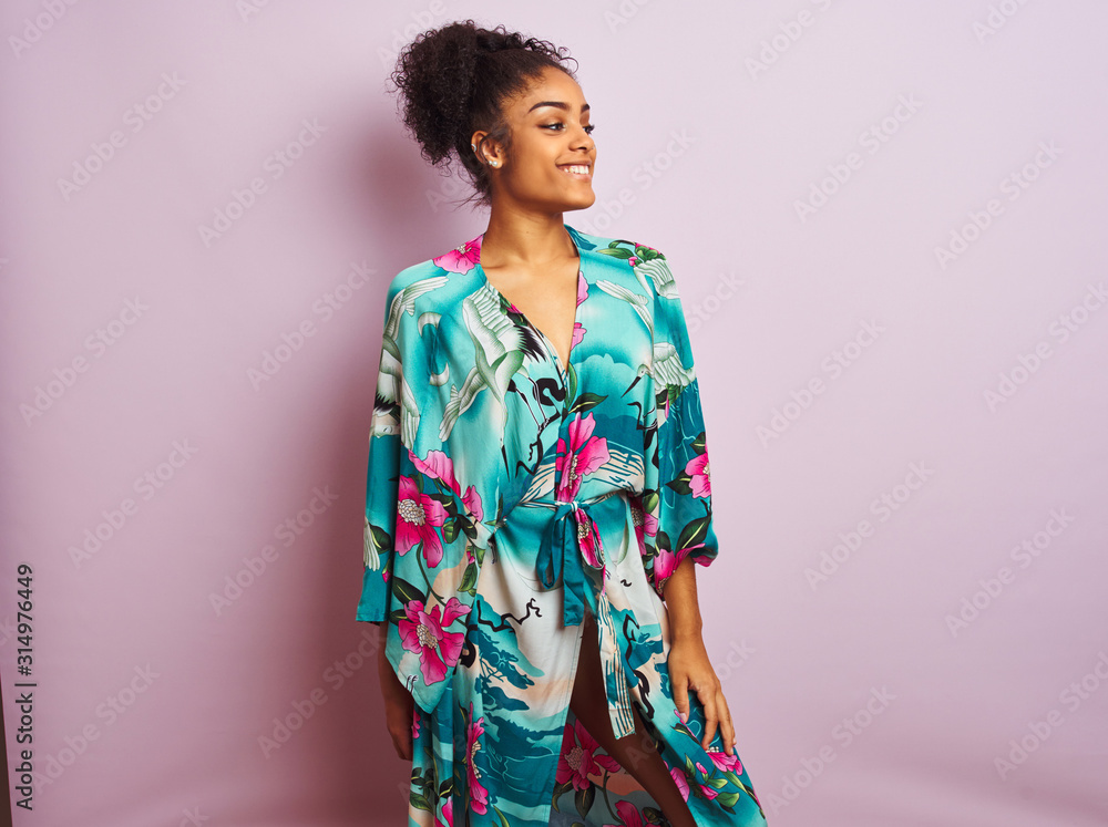 Young beautiful african american woman standing wearing elegant colorful caftan Young beautiful african american woman standing wearing elegant colorful caftan