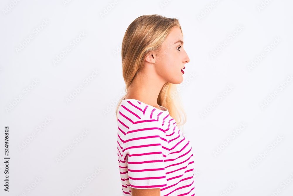 Young beautiful woman wearing pink striped t-shirt standing over isolated white background looking to side, relax profile pose with natural face with confident smile. Young beautiful woman wearing pink striped t-shirt standing over isolated white background looking to side, relax profile pose with natural face with confident smile.