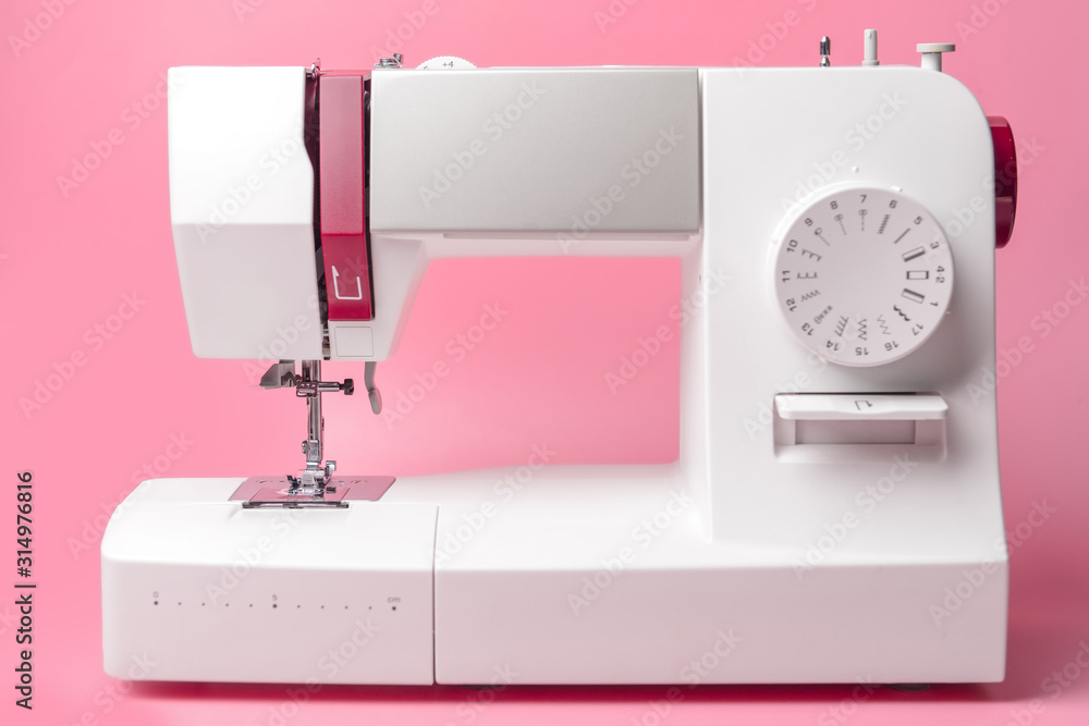 Sewing machine on color background