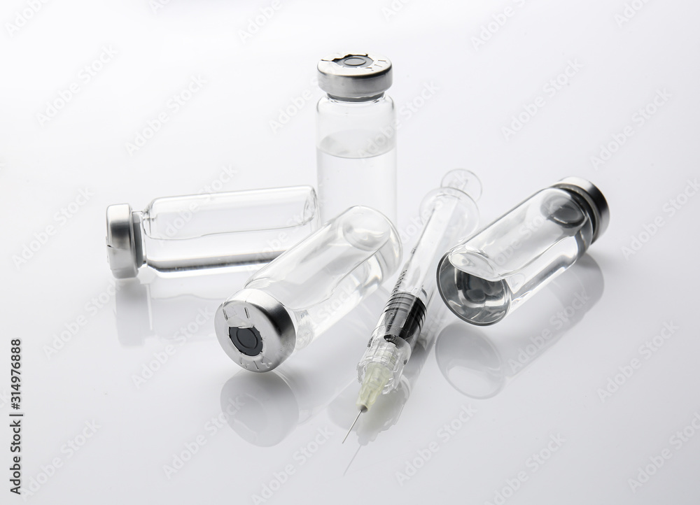 Syringe and ampules with filler for cosmetology on white background Syringe and ampules with filler for cosmetology on white background