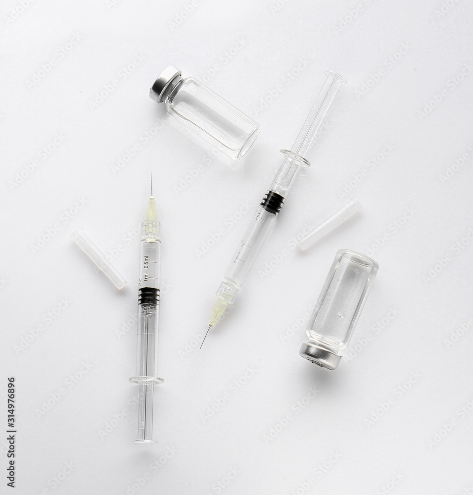 Syringes and ampules with filler for cosmetology on white background Syringes and ampules with filler for cosmetology on white background