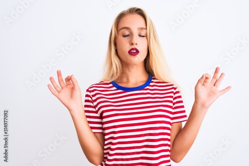 Wallpaper Mural Young beautiful woman wearing red striped t-shirt standing over isolated white background relax and smiling with eyes closed doing meditation gesture with fingers. Yoga concept. Torontodigital.ca