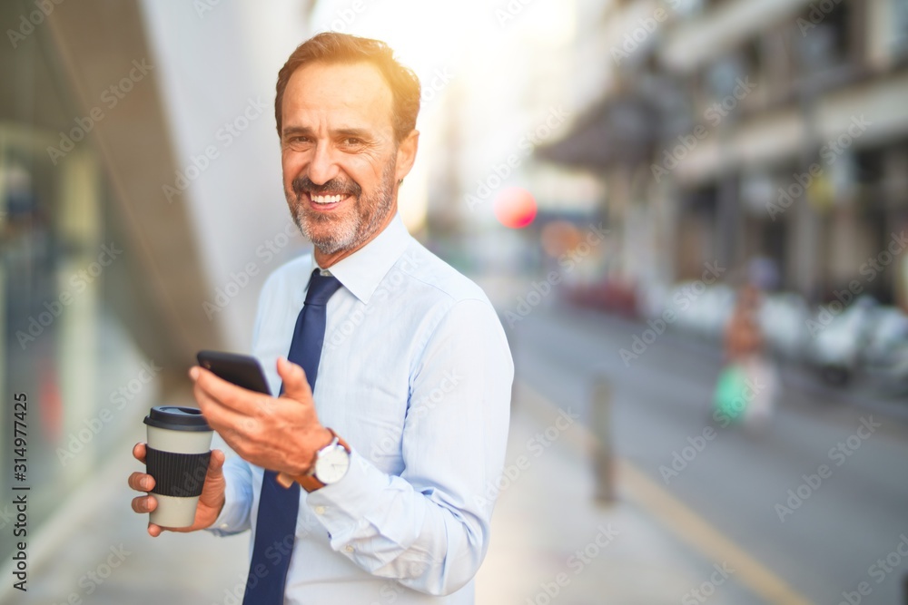 Middle age handsome businessman using smartphone drinking take away coffee smiling Middle age handsome businessman using smartphone drinking take away coffee smiling