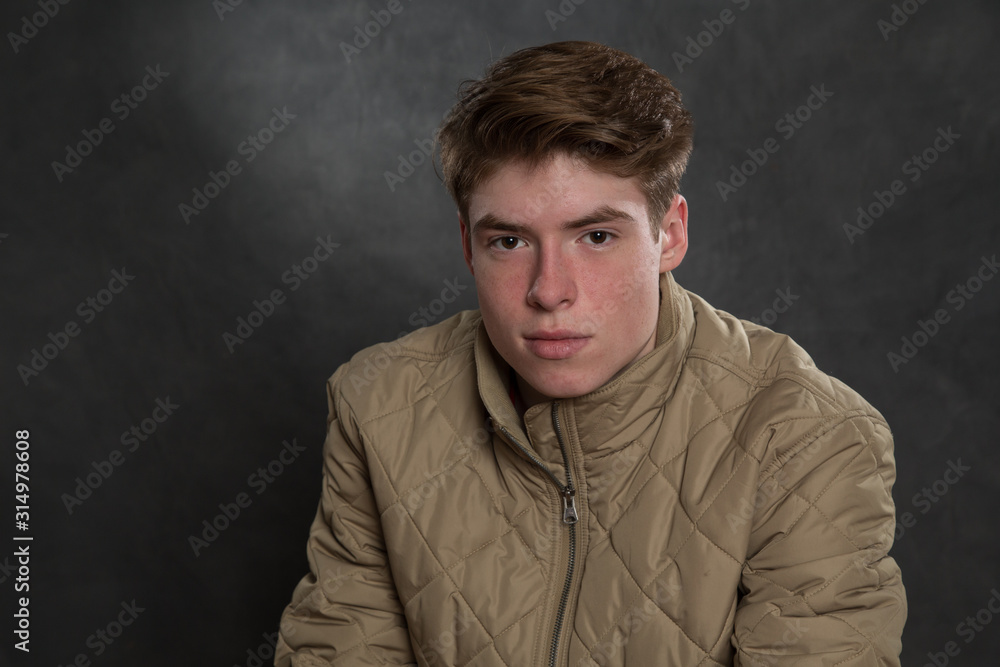 Fototapeta premium Portrait of teenage boy in studio wearing jacket