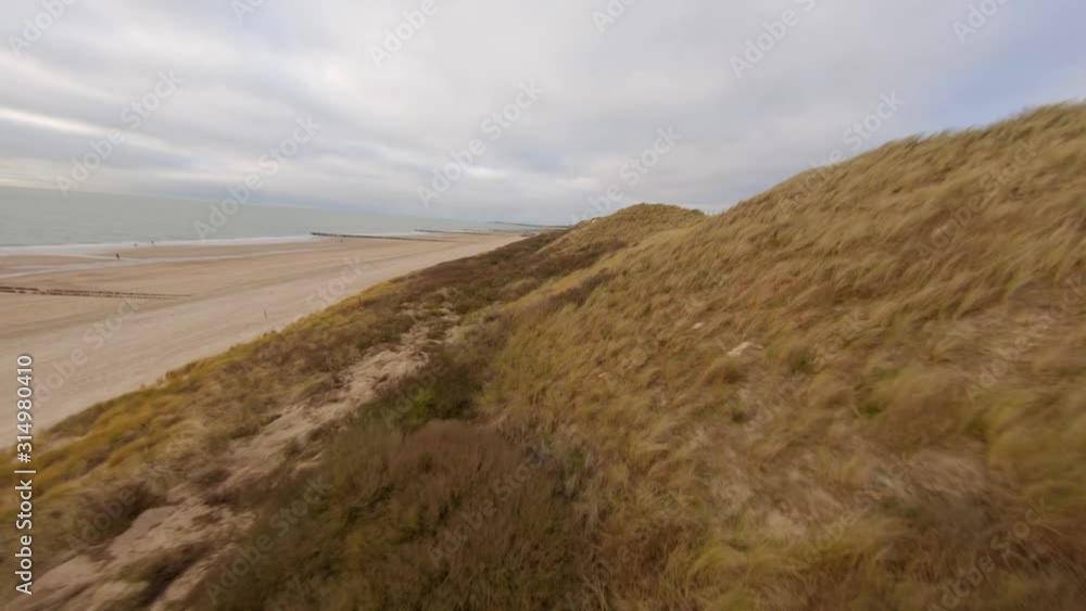 Soaring low above the dunes and beach during a windy day. Aerial shot. Soaring low above the dunes and beach during a windy day. Aerial shot.