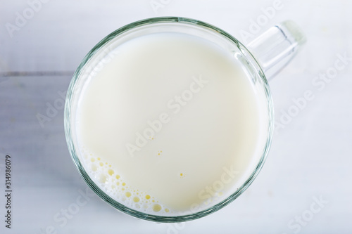 Glass of milk on wooden background. Top of view.