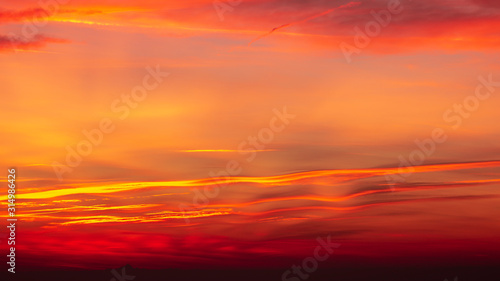 Fototapeta Naklejka Na Ścianę i Meble -  Bergamo, Italy. Fiery sunset over the Po valley and the Alps. Clouds that create light red and orange waves. Fabulous contest. Warm colors