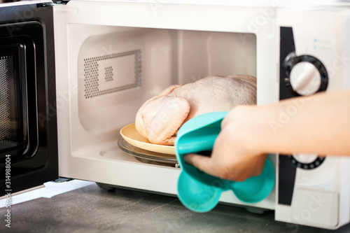 Quadro em tela Raw chicken in the microwave