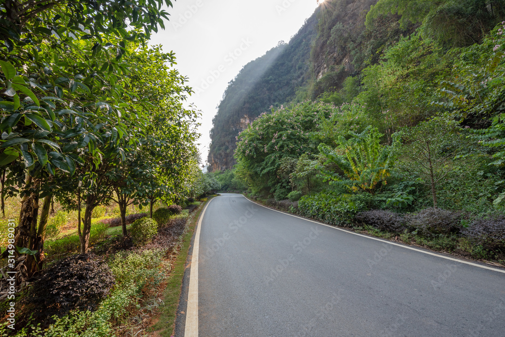 Empty road with karst hills in the background in Yangshuo, Guilin, Guangxi province, China Empty road with karst hills in the background in Yangshuo, Guilin, Guangxi province, China