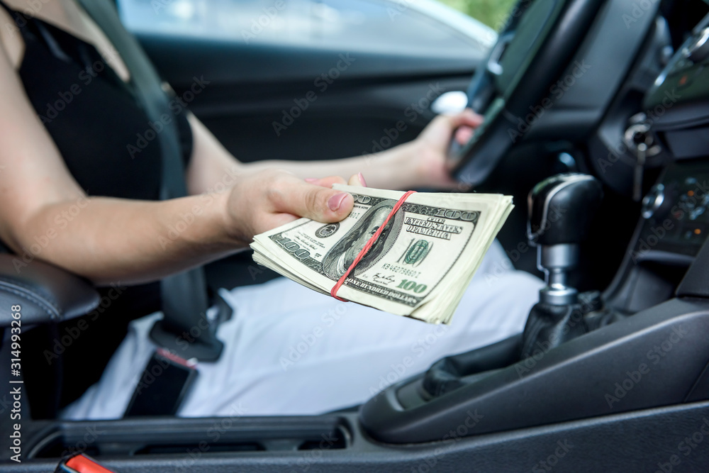 Bribery. Woman sitting in driver seat and giving dollar bundle Bribery. Woman sitting in driver seat and giving dollar bundle