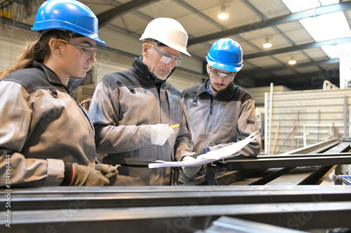 Steelwork instructor with young apprentice in workshop photo