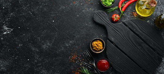 Dark cooking banner. Vegetables and spices on the kitchen table. Top view. Free space for your text.