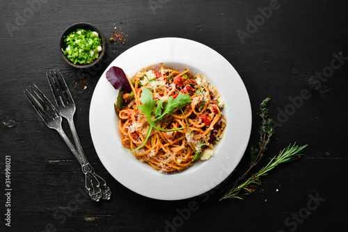 Pasta with tomatoes and vegetables. Carbonara. Italian cuisine. Top view. Free space for your text.