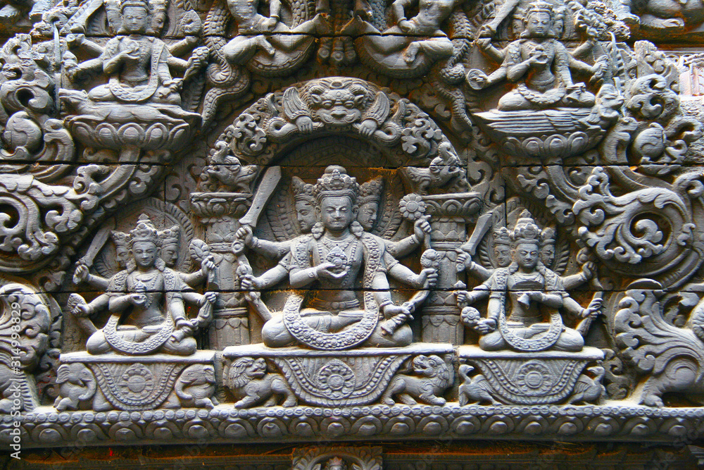 Relief aus Holz in schwarz mit Shiva im Lotussitz, Vishnu und andere Götter, hinduistisch buddhistisch religiös geprägte Ornamente am Tempel beim Dubar Square in Kathmandu, Nepal, Asien, Verehrung 