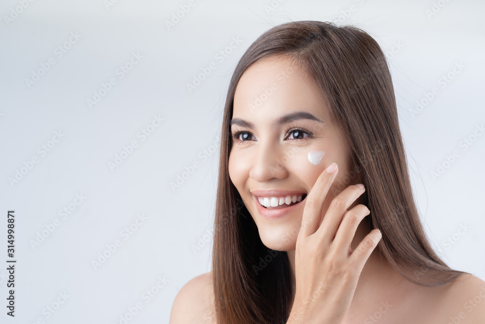 Asian woman. She is applying lotion on the face. Asian woman. She is applying lotion on the face.