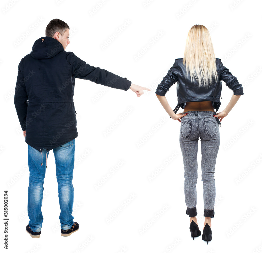 Back view of couple couple in winter jackets pointing. Back view of couple couple in winter jackets pointing.