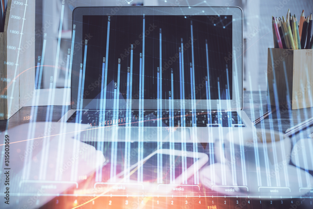 Stock market chart hologram drawn on personal computer background. Double exposure. Concept of investment.