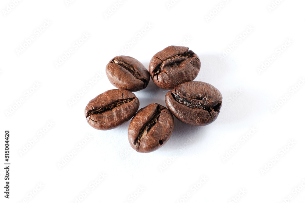 Coffee beans lie on a white sheet of paper Coffee beans lie on a white sheet of paper