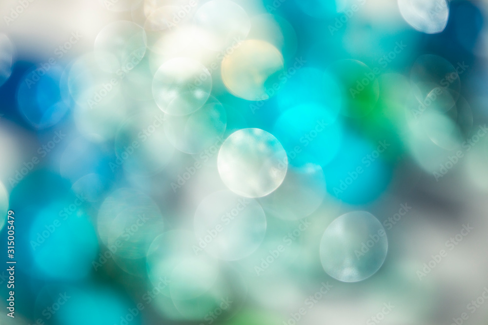 Blue green bright natural bokeh background. Circles of turquoise blurred light. Abstract bright shiny background.