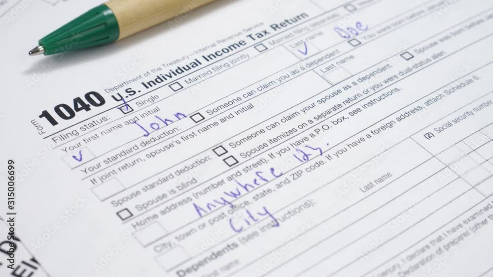IRS 1040 U.S. Tax Form and Green Pen. Taxpayers paperwork routine and bureaucracy concept. Wage and tax statement concept IRS 1040 U.S. Tax Form and Green Pen. Taxpayers paperwork routine and bureaucracy concept. Wage and tax statement concept