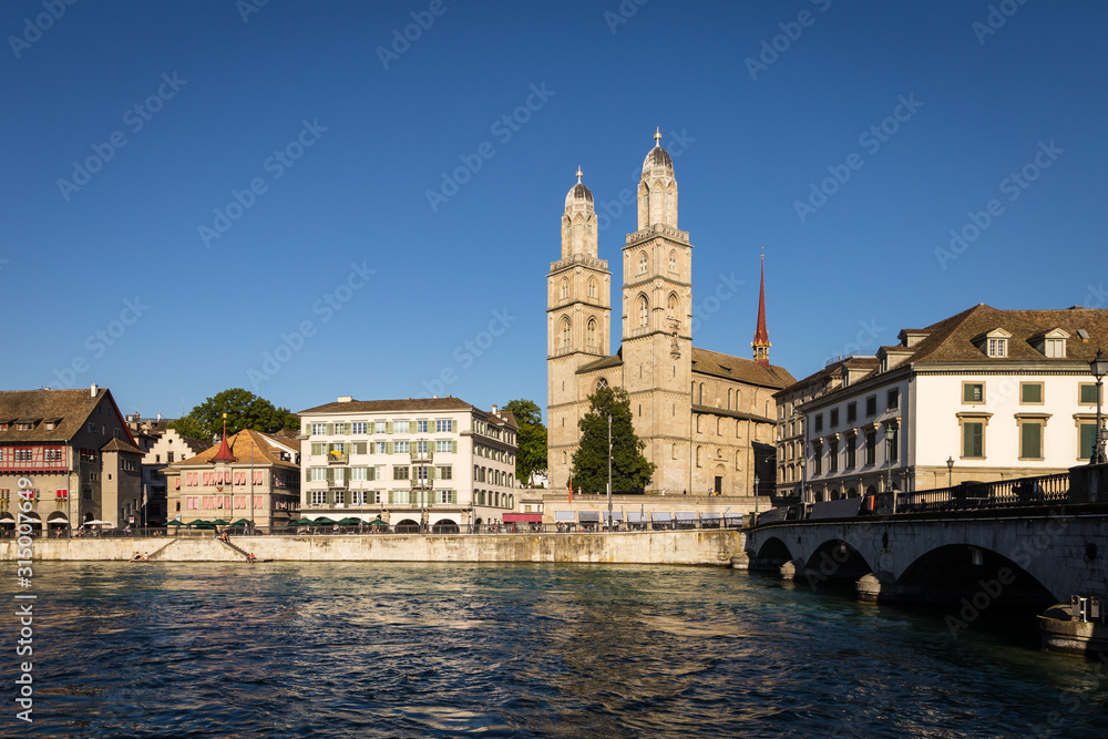 The famous Grossmunster cathedral by the Limmat river in Zurich old town in Switzerland largest city with a late evening light
