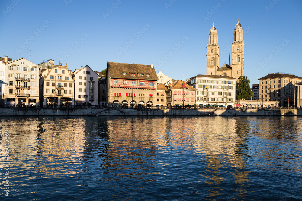 The famous Grossmunster cathedral by the Limmat river in Zurich old town in Switzerland largest city with a late evening light