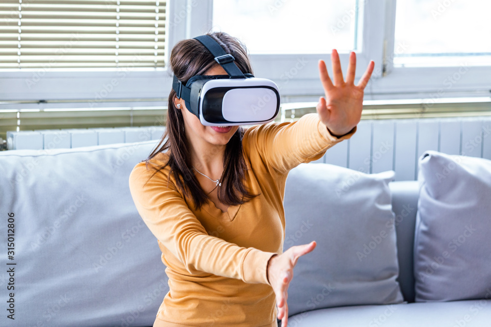Excited young woman wearing virtual reality glasses and screaming because of unbelievable effects in 3d digital world. Impressed girl yelling and gesturing when using VR technology for the first time Excited young woman wearing virtual reality glasses and screaming because of unbelievable effects in 3d digital world. Impressed girl yelling and gesturing when using VR technology for the first time