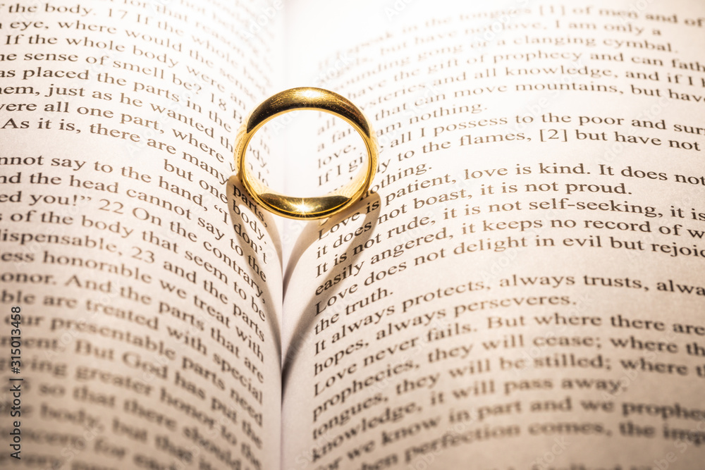 Fototapeta premium Golden wedding ring on bible book