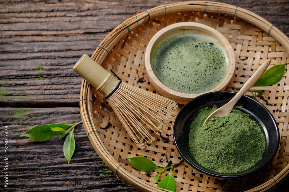 Japanese organic matcha green tea powder in bowl with wire whisk and green tea leaf on wooden background, Organic product from the nature for healthy with traditional style Japanese organic matcha green tea powder in bowl with wire whisk and green tea leaf on wooden background, Organic product from the nature for healthy with traditional style