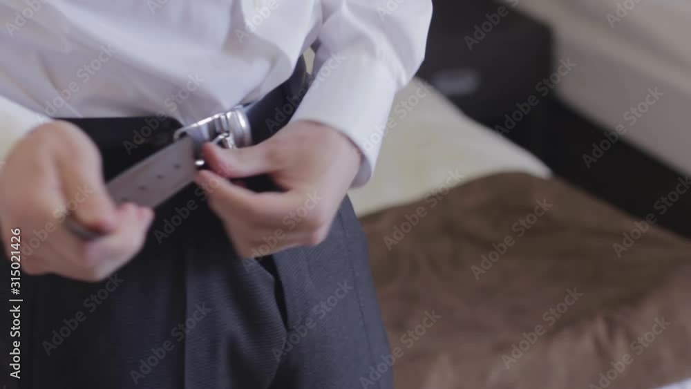 the man fastens the belt on his pants the man fastens the belt on his pants
