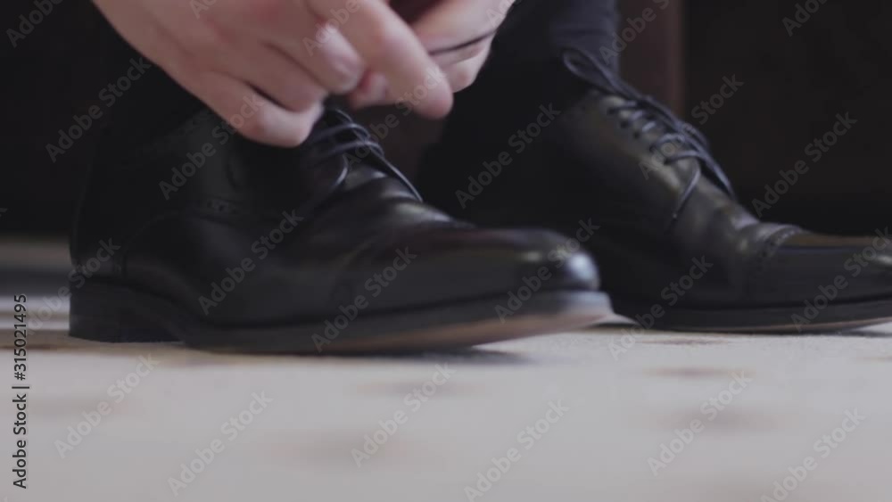 the man is lacing up his shoes the man is lacing up his shoes