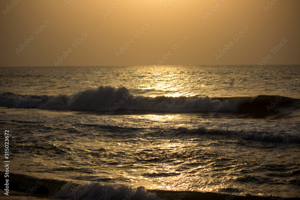 Early morning orange lighting sea water waves, marina beach, in Chennai, Tamilnadu Early morning orange lighting sea water waves, marina beach, in Chennai, Tamilnadu