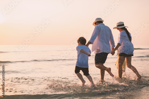 Happy family having fun walking hand in hand on beach at sunset. Happy family having fun running on beach at sunset.
