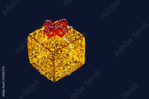 Christmas glowing gift box from yellow and red garlands isolated on dark background
