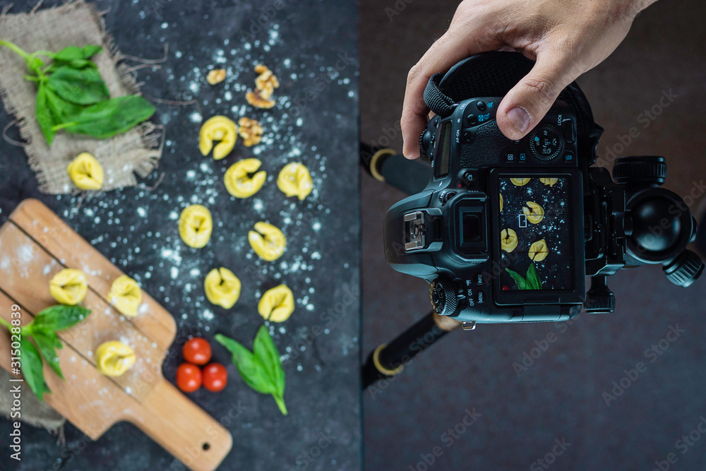 Photo camera on tripod capturing an image about fresh pasta making Photo camera on tripod capturing an image about fresh pasta making