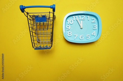 alarm clock and mini trolley cart with space copy on Yellow background photo