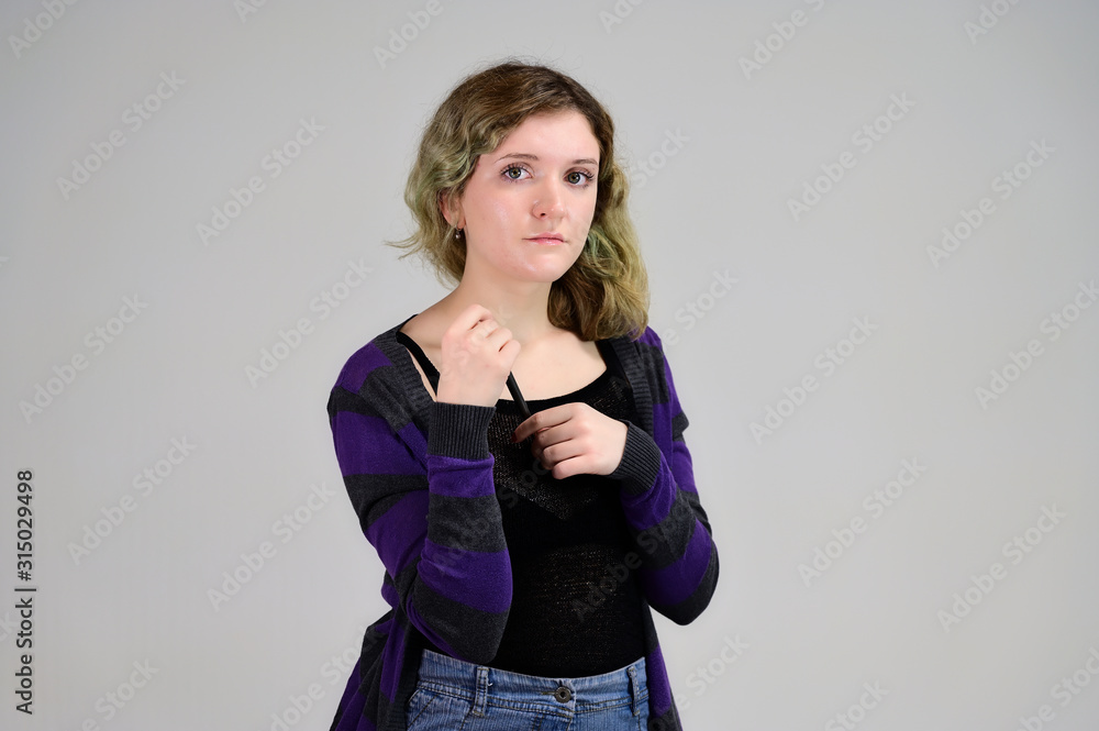 Portrait of a pretty student girl with beautiful curly hair. Concept horizontal photo of a young woman with emotions in a dark jacket standing in front of the camera on a white background. Portrait of a pretty student girl with beautiful curly hair. Concept horizontal photo of a young woman with emotions in a dark jacket standing in front of the camera on a white background.