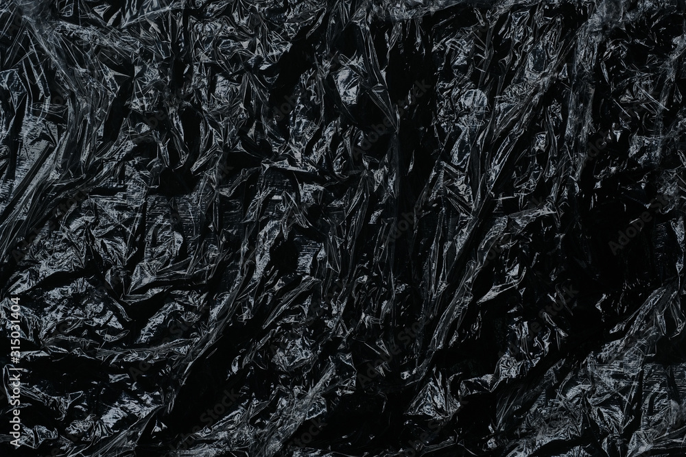 Stretching tape of polyethylene with reflexes and highlights on black background. Stretching tape of polyethylene with reflexes and highlights on black background.