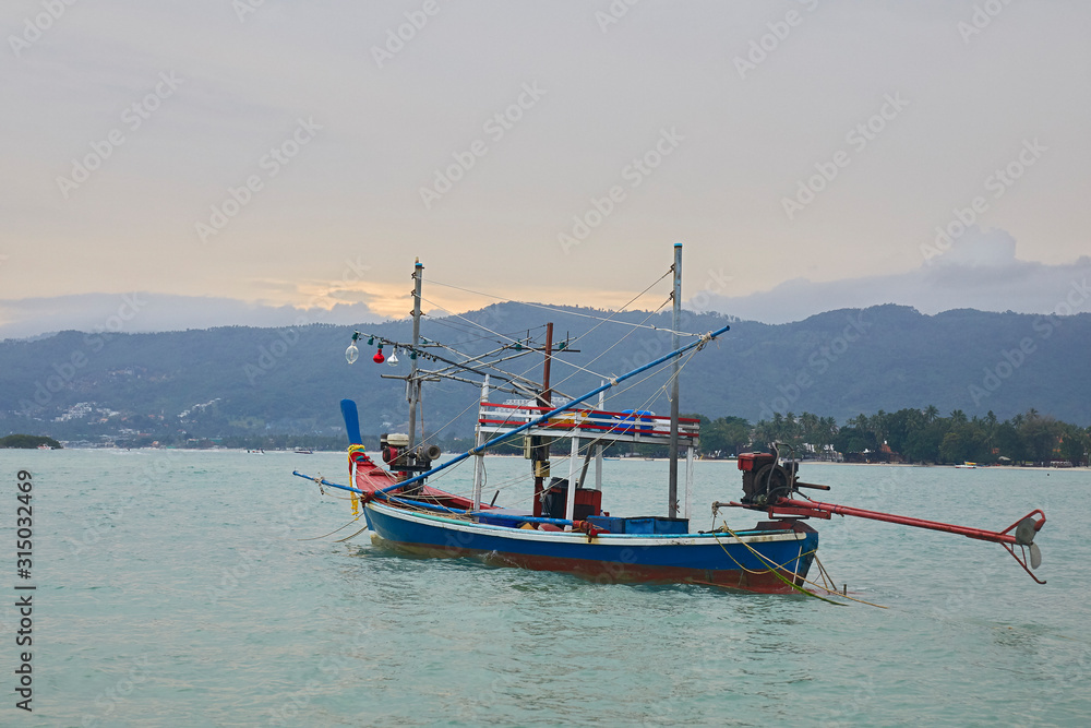 Fototapeta premium Wooden fishing boat against the evening sky