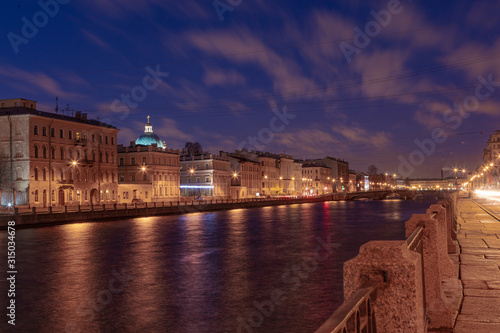 Beautiful dawn in St. Petersburg over the river. Reflection in the water of lanterns.