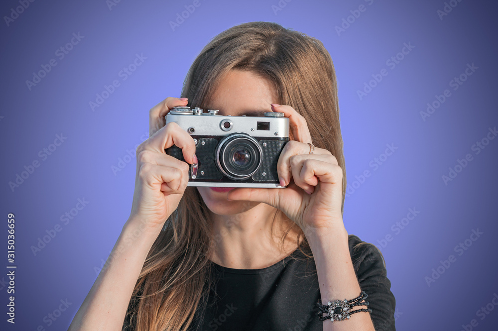 Stylish young girl photographer taking photos with a retro camera Stylish young girl photographer taking photos with a retro camera