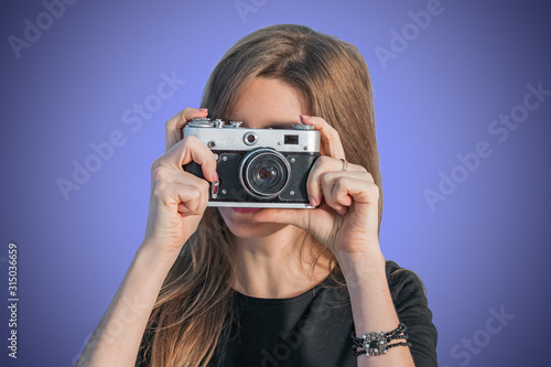 Stylish young girl photographer taking photos with a retro camera © andyborodaty