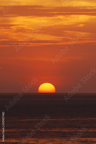 Fototapeta Naklejka Na Ścianę i Meble -  Nature landscape of Tranquil scene red sun and  red sky sunset over the sea at phuket Thailand.- Red Orange Nature Backdrops Texture 