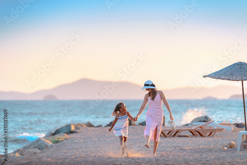 Young mother with her daughter walking at the promenade alley