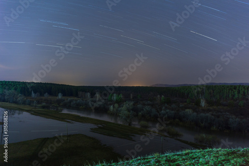 Star traces are reflected in the river during a flood. Russia. long shutter speed. selective focus