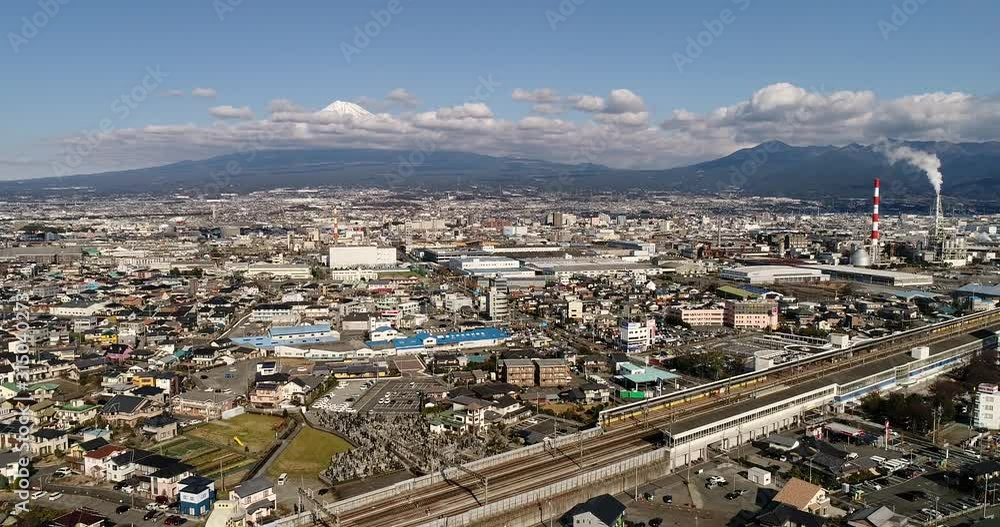 Railway rapid trains station in Shin-Fuji city on Japan coast in view of iconic Fujiyama mountain covered by snow during winter season. Railway rapid trains station in Shin-Fuji city on Japan coast in view of iconic Fujiyama mountain covered by snow during winter season.