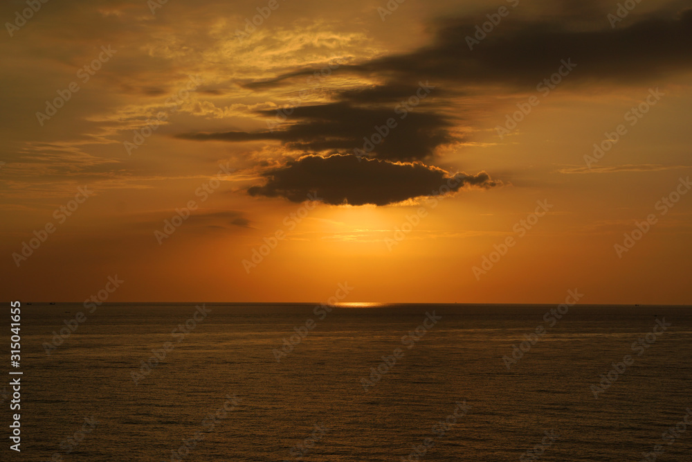 Nature seascape of Tranquil scene Sun behind the dark clouds and twilight sky sunset  over the sea at phuket Thailand. - Travel nature backdrops                               
