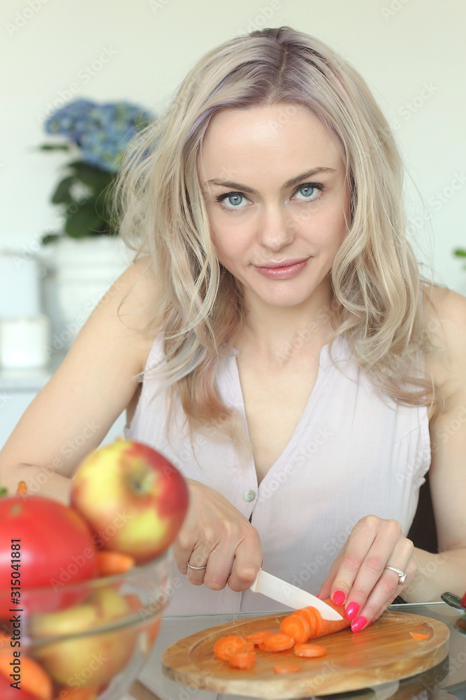 young positive smiling woman with vegetables in the kitchen young positive smiling woman with vegetables in the kitchen