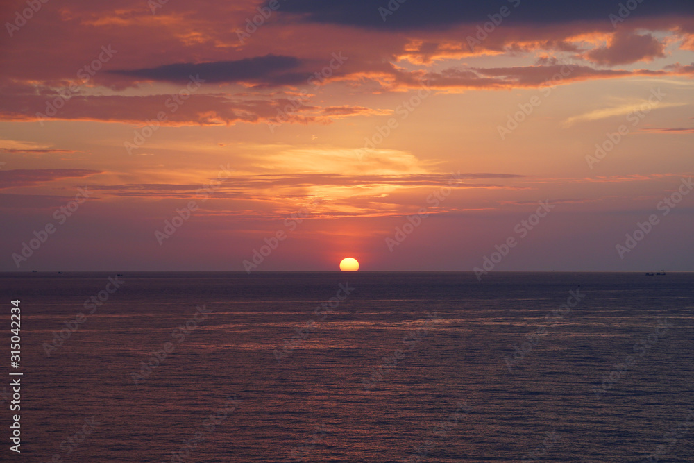 Nature seascape of Tranquil sunset scene. Sun and dark clouds with twilight sky over the sea at phuket Thailand - image Travel nature backdrop background and copy space                           