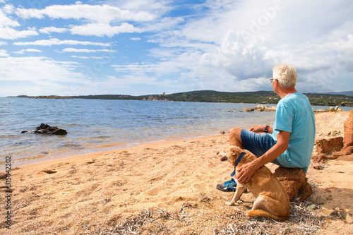 Man with dog at the coast from Corsica with Genoese tower